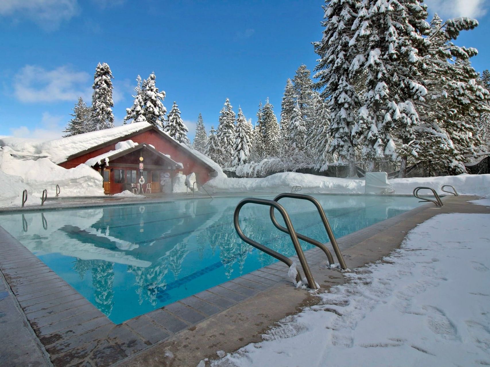 Granlibakken heated outdoor pool surrounded by snow, trees, and resort buildings